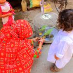 A woman feeding her pet parrots on the street on Jaipur