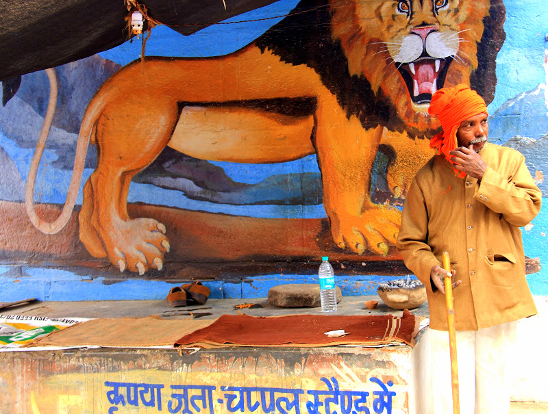 a man in front of a mural in Varanasi
